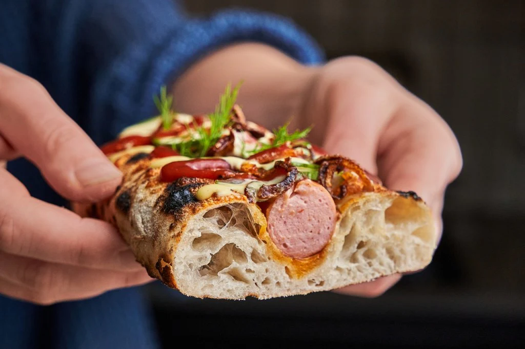Hand-held pizza dog showing the airy crumb